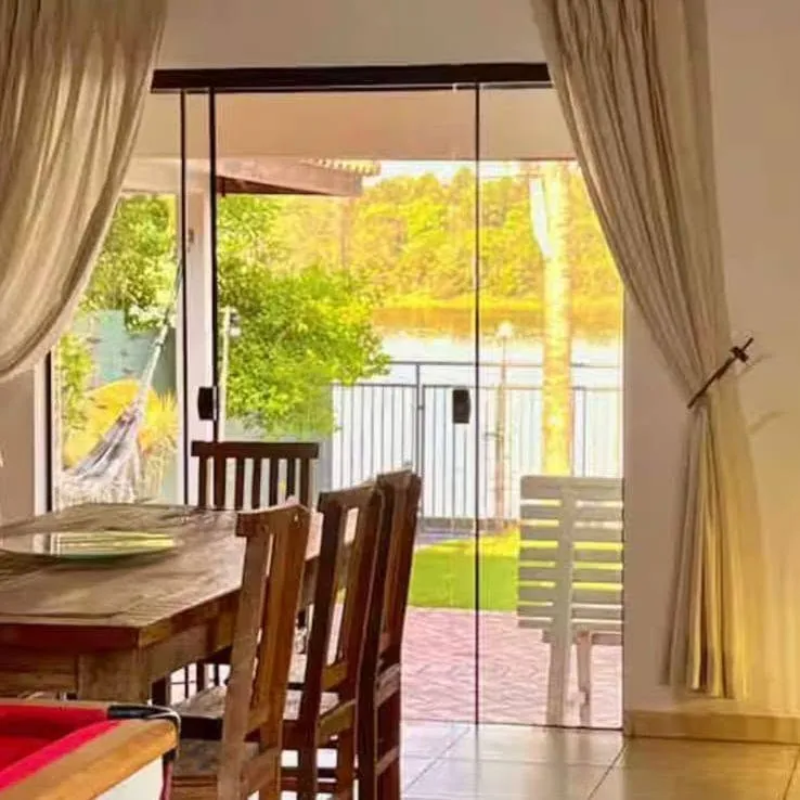 Sala de jantar da casa no Botolan com vista para o jardim e a represa